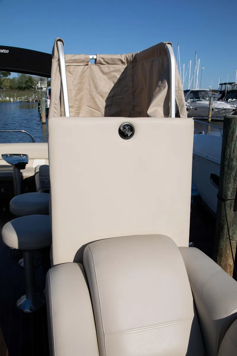 Slide: The Image of 2018 Godfrey 255 ULB boat interior with beige seating and marina background. - 17