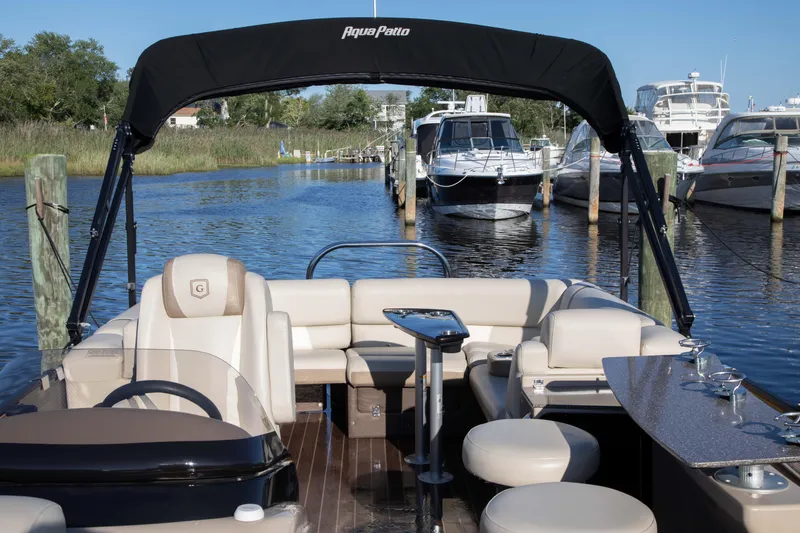 Slide: The Image of 2018 Godfrey 255 ULB pontoon boat with seating, docked in a marina. - 2