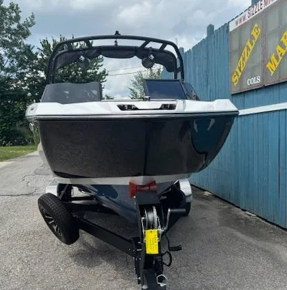 Slide: The Image of 2023 Yamaha Boats 222SD on trailer, sleek design, parked outdoors. - 1