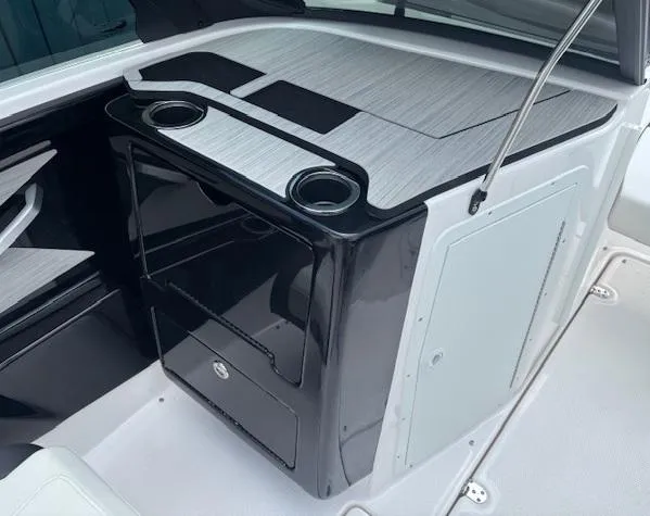 Slide: The Image of 2023 Yamaha Boats 222SD interior with sleek black cabinetry and integrated cup holders. - 16