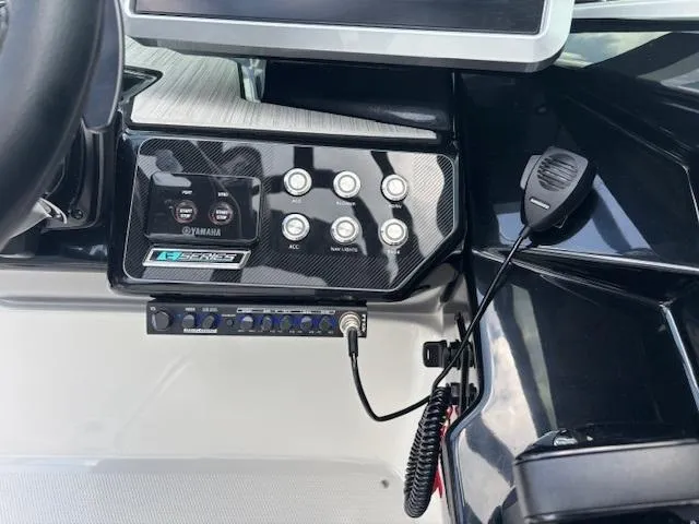 Slide: The Image of Control panel of 2023 Yamaha Boats 222SD with buttons and microphone. - 24