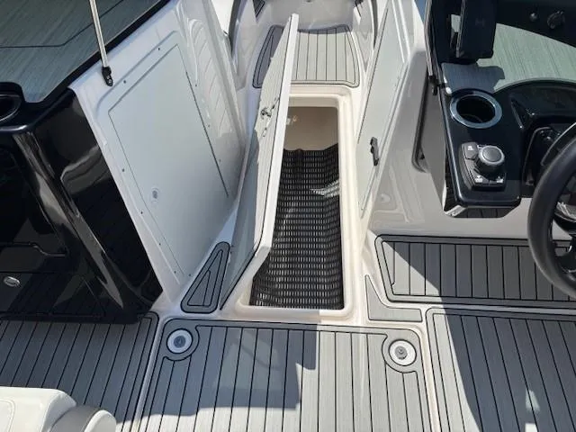 Slide: The Image of 2023 Yamaha Boats 222SD interior with open storage compartment and sleek deck design. - 26