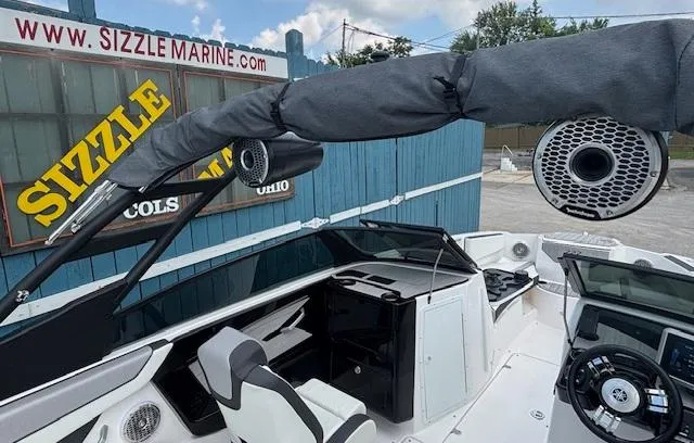 Slide: The Image of 2023 Yamaha Boats 222SD interior with speakers, steering wheel, and seating at Sizzle Marine. - 29