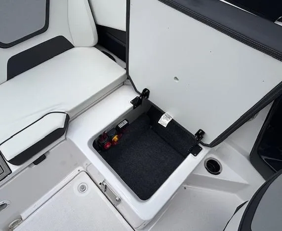 Slide: The Image of 2023 Yamaha Boats 222SD storage compartment with open lid, showcasing interior space and seating. - 36