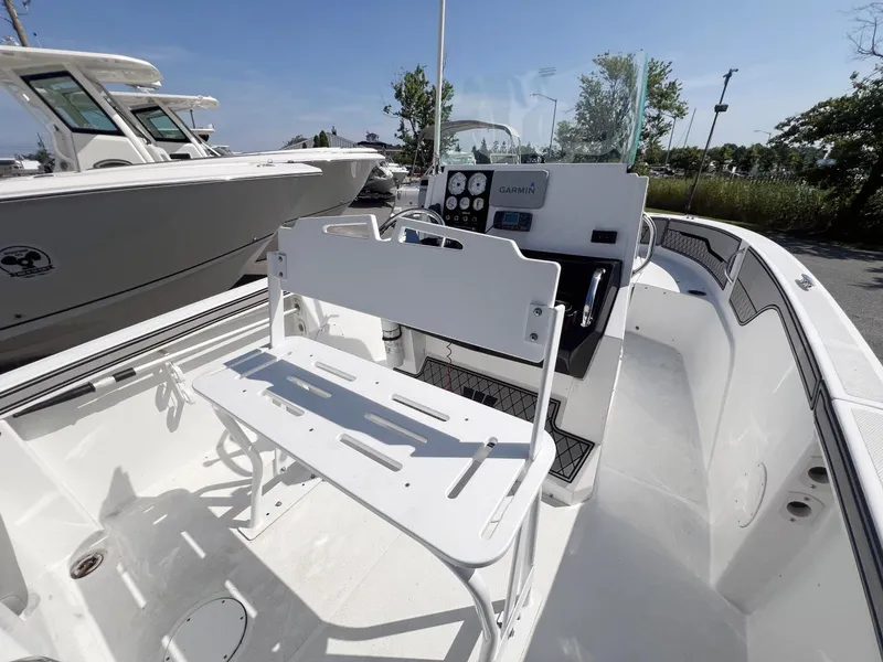 Slide: The Image of 2020 Wellcraft 182 Fishmaster boat interior with Garmin dashboard, white seating, and spacious deck. - 13