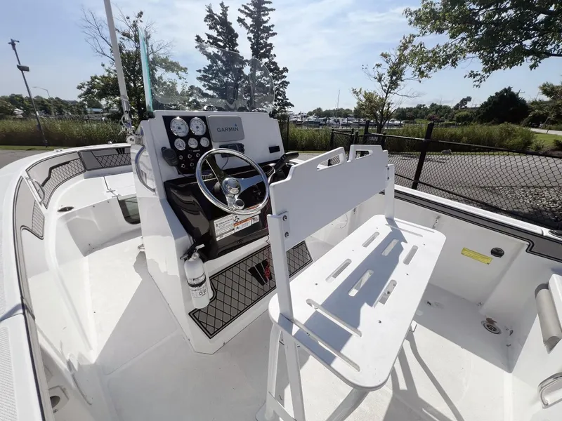 Slide: The Image of 2020 Wellcraft 182 Fishmaster boat interior with steering console and seating, docked outdoors. - 14