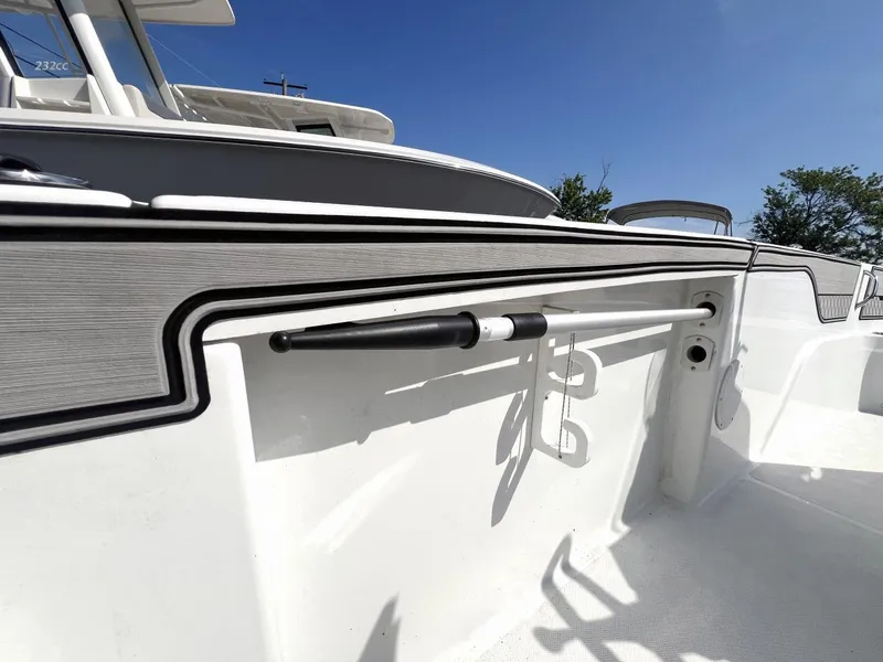 Slide: The Image of 2020 Wellcraft 182 Fishmaster boat interior with rod holder, sleek design, and clear blue sky. - 18