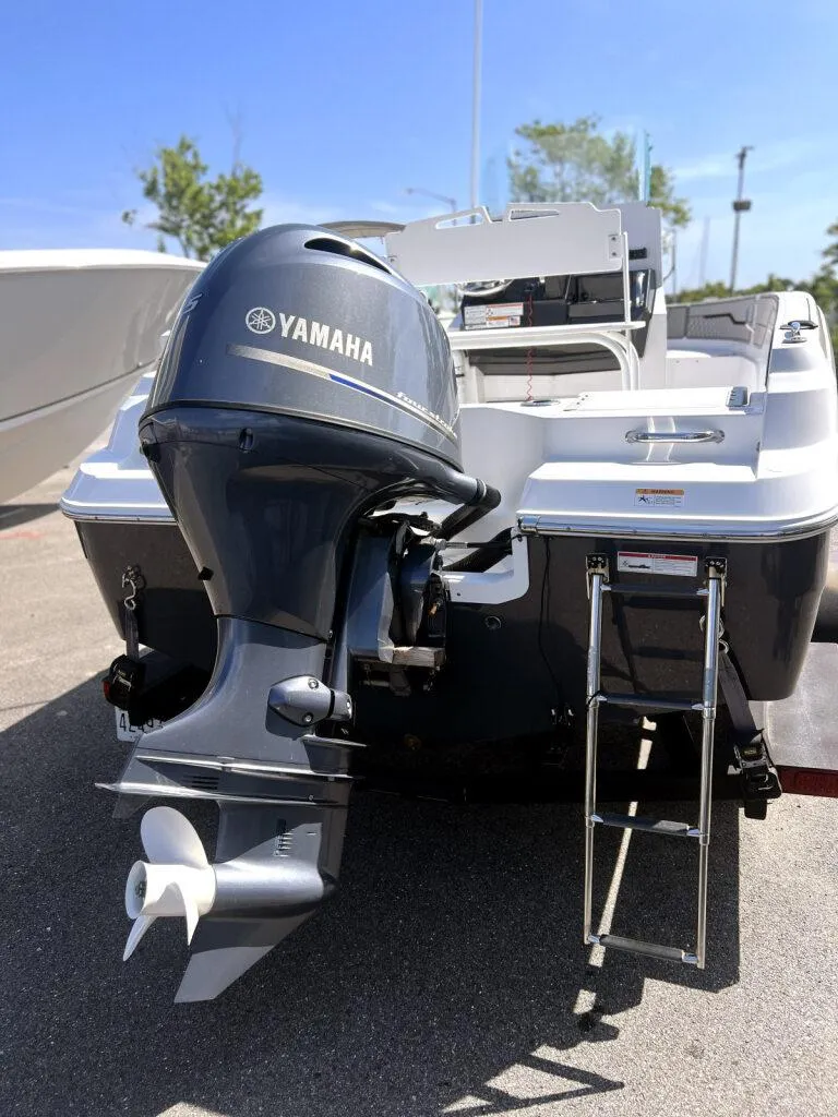 Slide: The Image of 2020 Wellcraft 182 Fishmaster boat with Yamaha outboard motor and ladder, parked on pavement. - 9