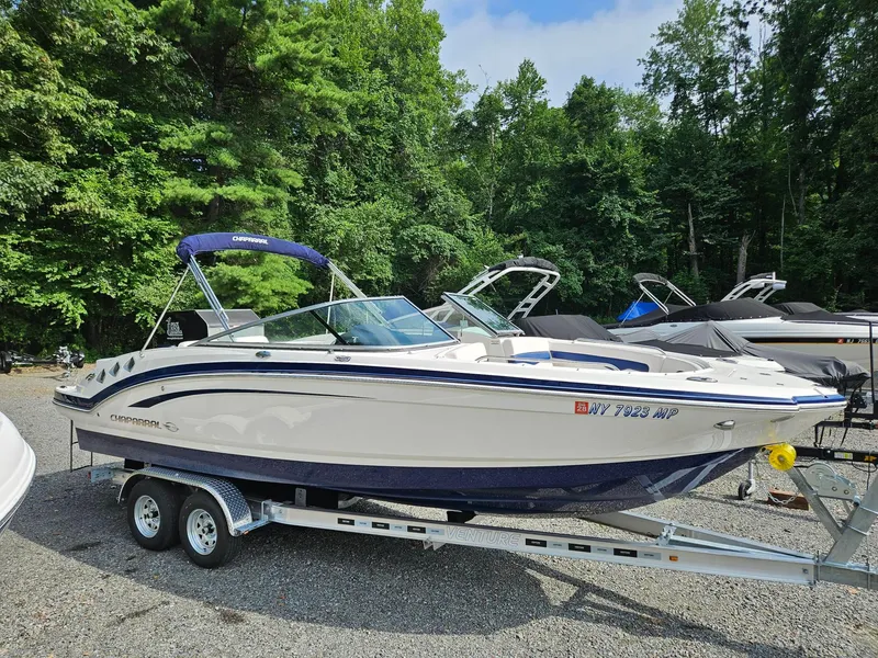 The Image of 2019 Chaparral 246 SSi boat on trailer, surrounded by trees and other boats. - 0