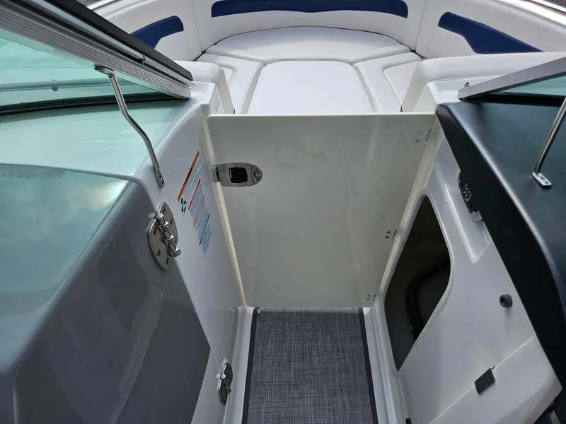 Slide: The Image of 2019 Chaparral 246 SSi boat interior with open door and seating area. - 14