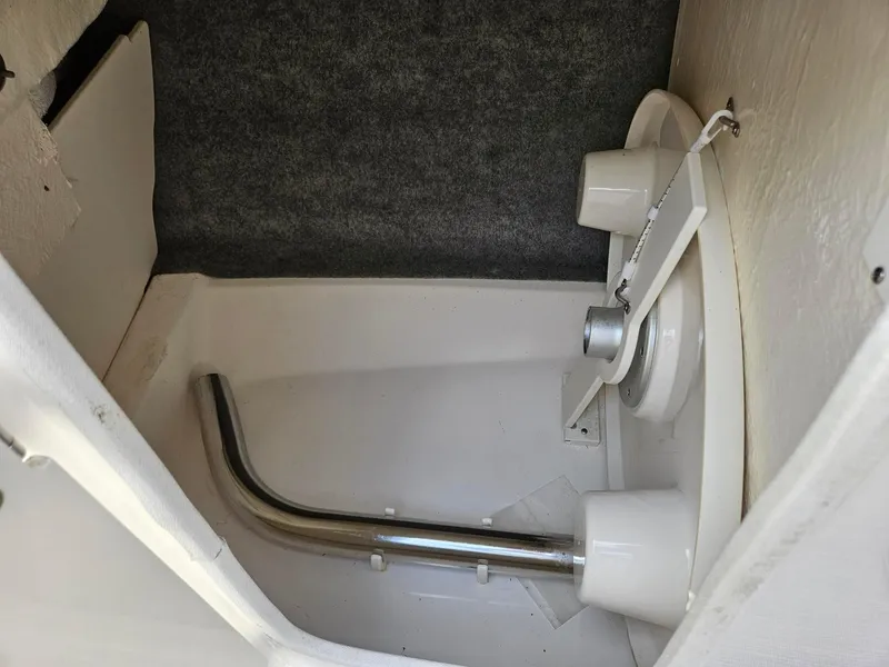 Slide: The Image of Interior of 2019 Chaparral 246 SSi boat, featuring storage compartment and metal pipe. - 18