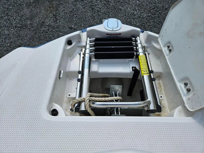 Slide: The Image of 2019 Chaparral 246 SSi boat anchor compartment with ladder and rope. - 21
