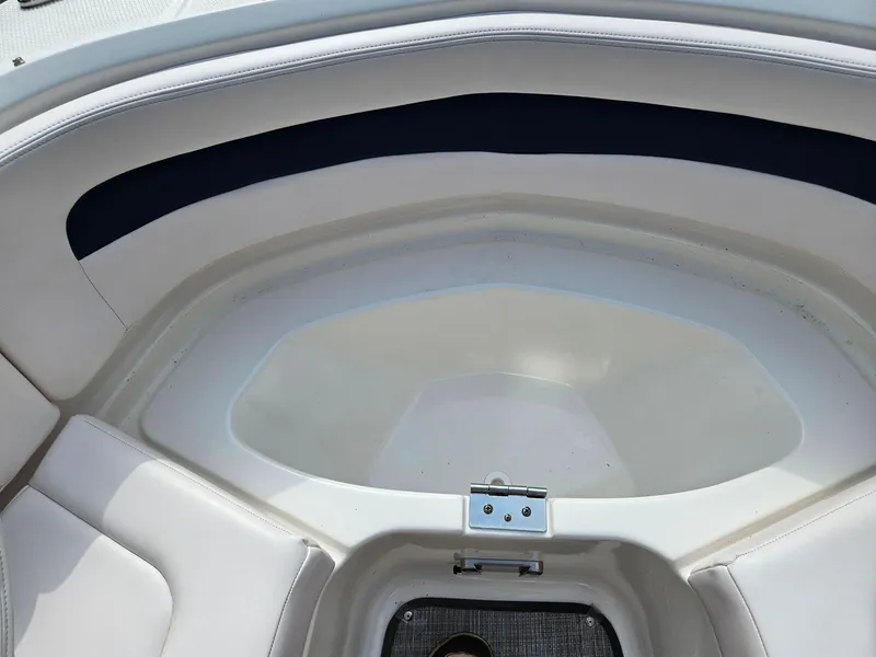 Slide: The Image of 2019 Chaparral 246 SSi boat interior, featuring white seating and storage compartment. - 23