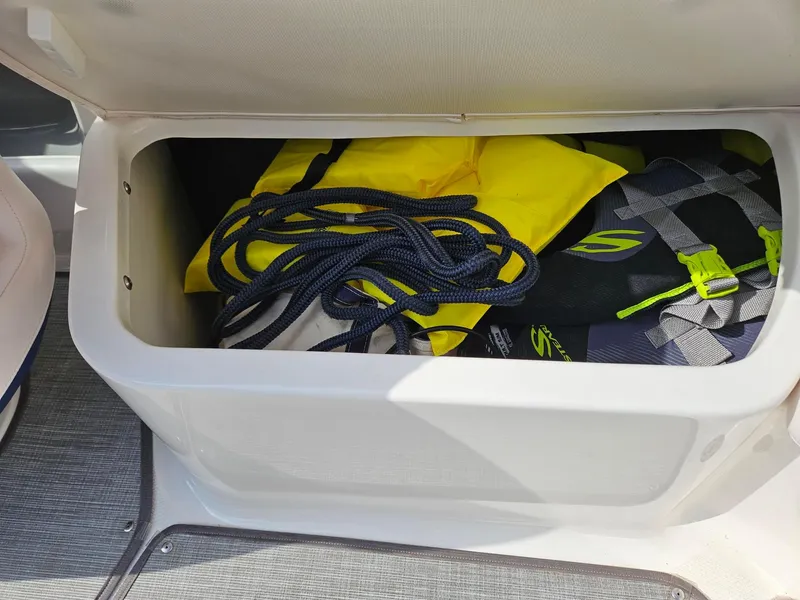 Slide: The Image of Storage compartment in 2019 Chaparral 246 SSi boat with life jackets and rope. - 25