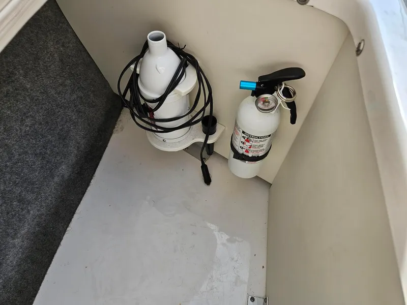 Slide: The Image of 2019 Chaparral 246 SSi boat storage with fire extinguisher and coiled cable. - 28