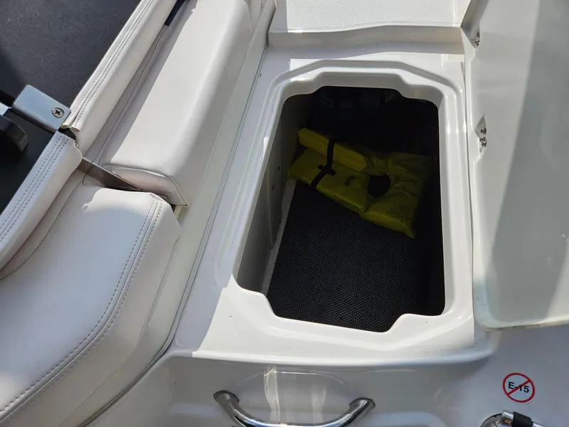Slide: The Image of Storage compartment in a 2019 Chaparral 246 SSi boat with a yellow life jacket inside. - 31
