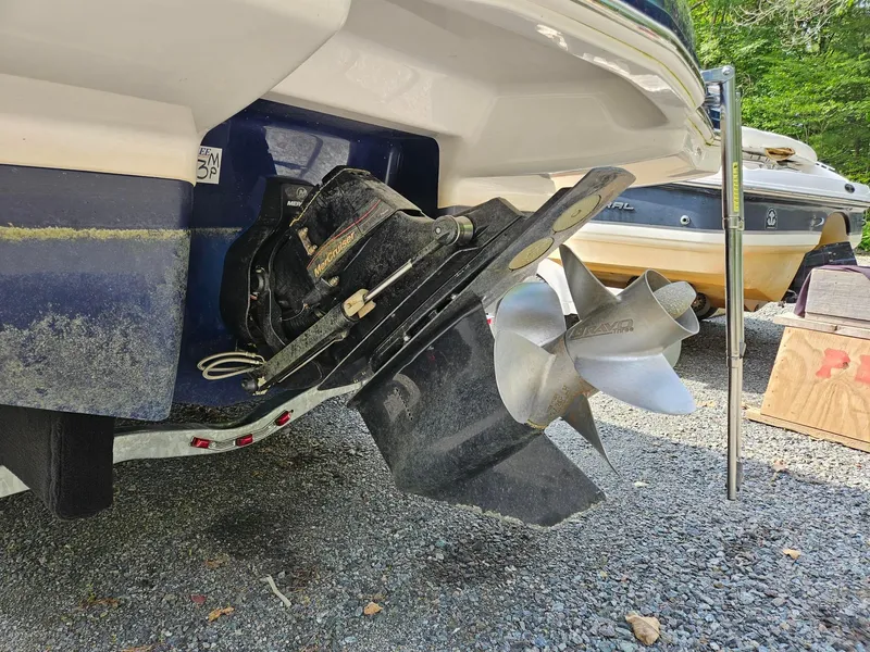 Slide: The Image of 2019 Chaparral 246 SSi boat with MerCruiser outdrive and propeller, parked on gravel. - 5