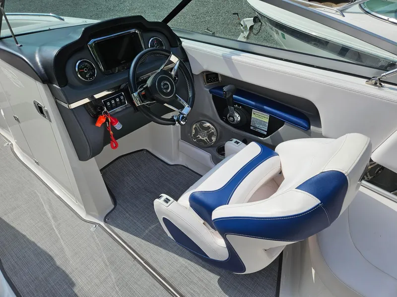 Slide: The Image of 2019 Chaparral 246 SSi boat cockpit with steering wheel and blue-white seating. - 7