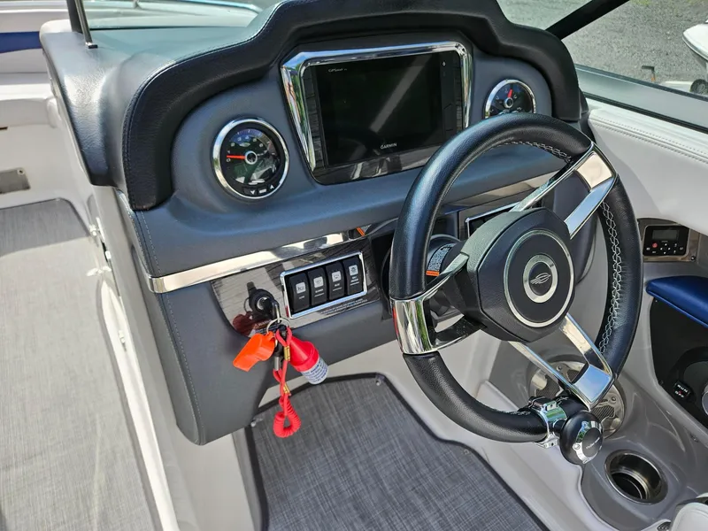 Slide: The Image of 2019 Chaparral 246 SSi boat dashboard with steering wheel and control panel. - 8