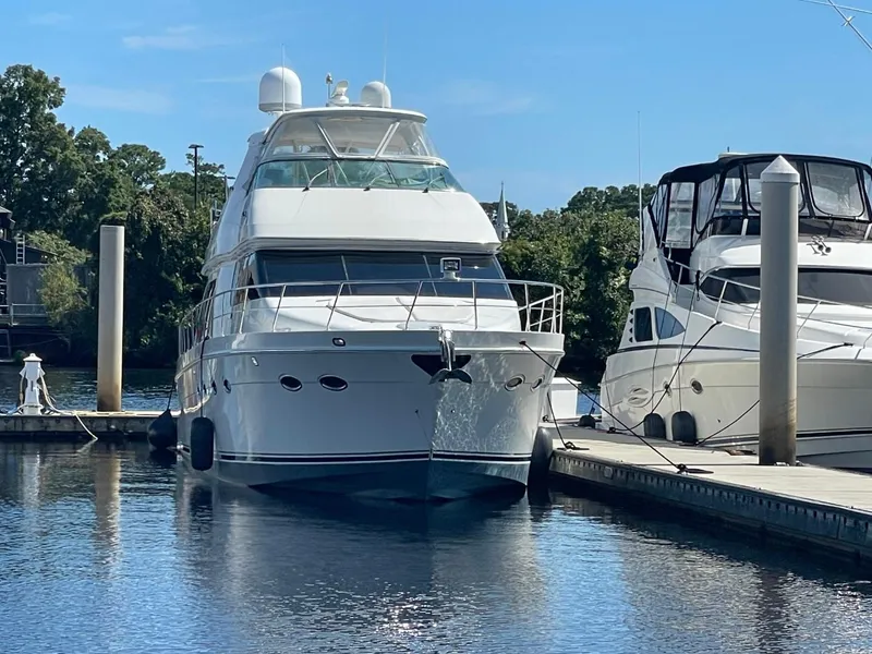 Slide: The Image of 2006 Carver 56 Voyager yacht docked at marina, surrounded by calm water and trees. - 10