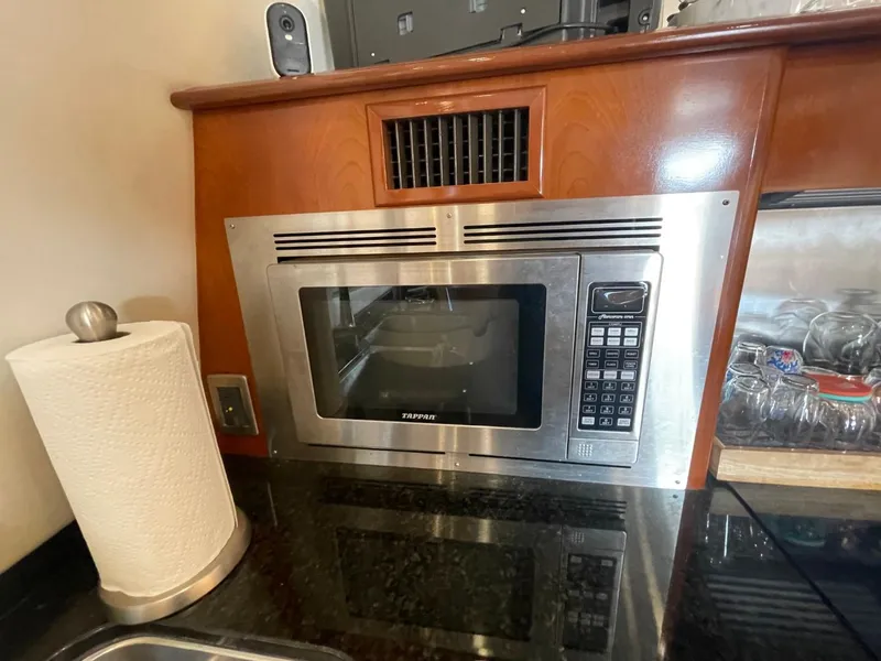 Slide: The Image of Built-in microwave in 2006 Carver 56 Voyager yacht kitchen, with paper towel holder and glassware. - 31