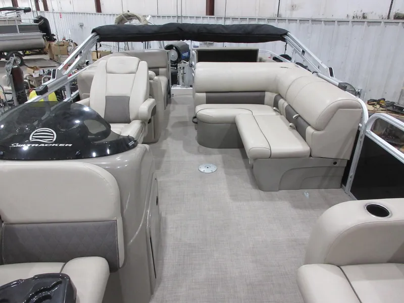 Slide: The Image of 2022 Sun Tracker Party Barge 22 RF DLX interior with beige seating and helm. - 4