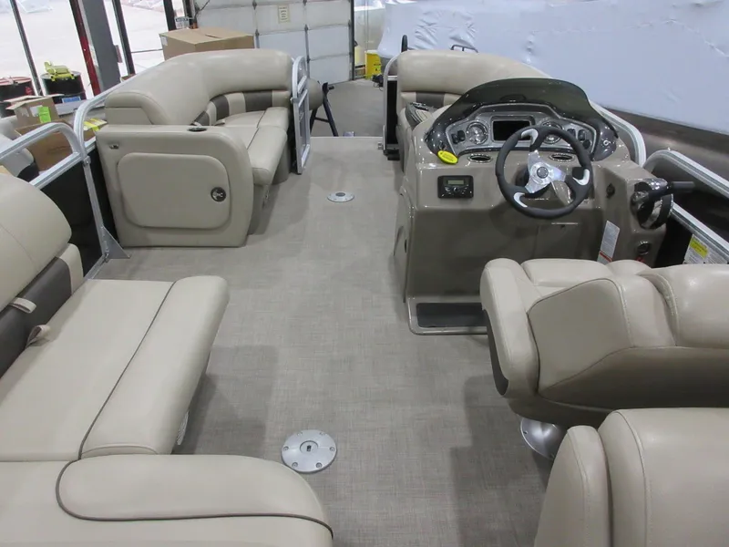 Slide: The Image of 2022 Sun Tracker Party Barge 22 RF DLX interior with beige seating and steering console. - 5