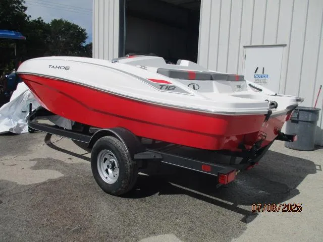 Slide: The Image of 2024 Tahoe T18 boat in red and white on a trailer outside a building. - 0