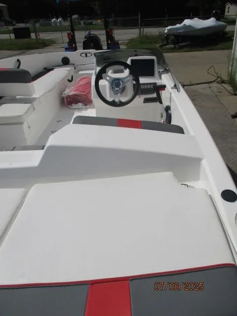 Slide: The Image of 2024 Tahoe T18 boat interior with steering wheel and seating, photographed outdoors. - 1