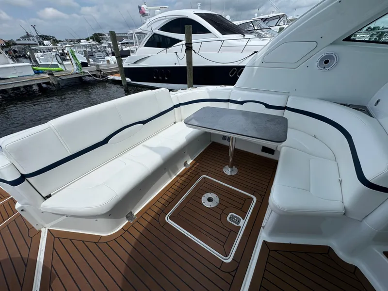 Slide: The Image of 2013 Formula 45 Yacht cockpit with white seating, wooden deck, and table at marina. - 20