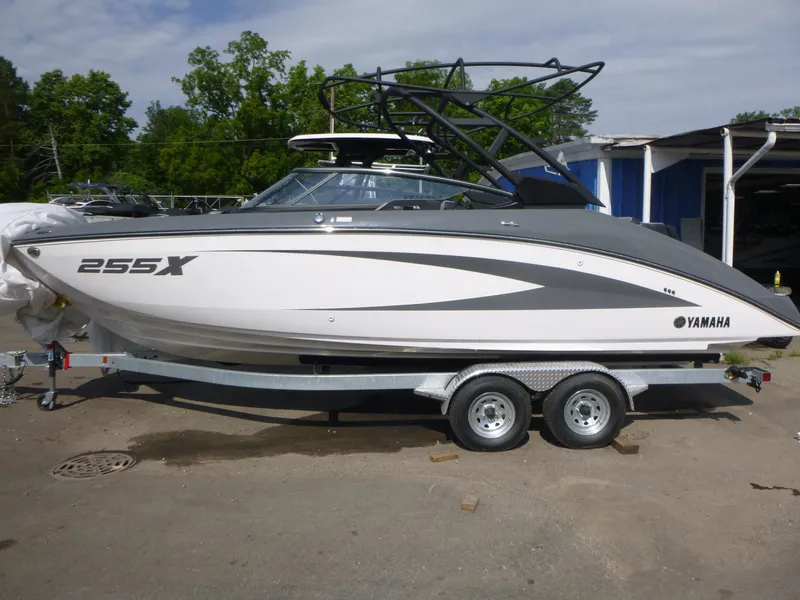 The Image of 2025 Yamaha Boats 255XE on trailer, sleek design, parked outdoors. - 1