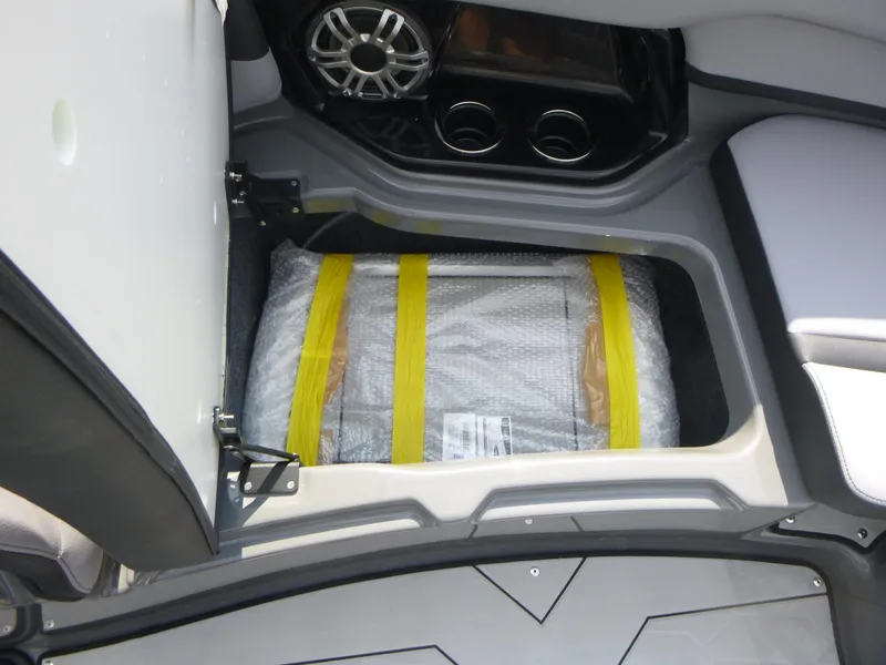 Slide: The Image of Storage compartment in 2025 Yamaha Boats 255XE, featuring secure packaging and cup holders. - 11