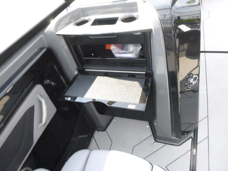 Slide: The Image of 2025 Yamaha Boats 255XE interior with storage compartment and cup holders. - 9
