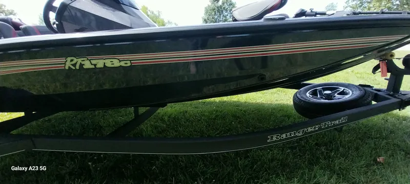 Slide: The Image of 2024 Ranger RT178C boat on trailer, side view, parked on grass. - 12