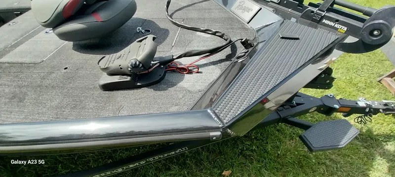 Slide: The Image of 2024 Ranger RT178C boat deck with seat and trolling motor on grass. - 15