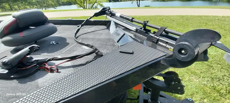 Slide: The Image of 2024 Ranger RT178C boat with Minn Kota trolling motor, parked near a scenic lake. - 16