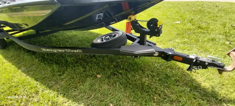 Slide: The Image of 2024 Ranger RT178C boat trailer on grass, featuring sturdy frame and spare tire. - 17