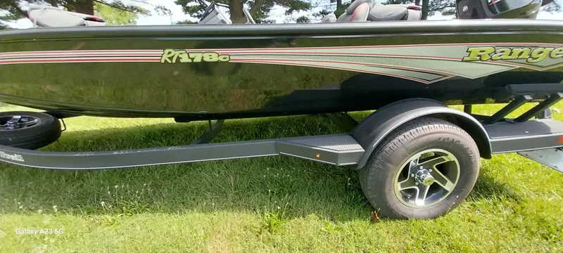 Slide: The Image of 2024 Ranger RT178C boat on trailer, side view, parked on grass. - 27