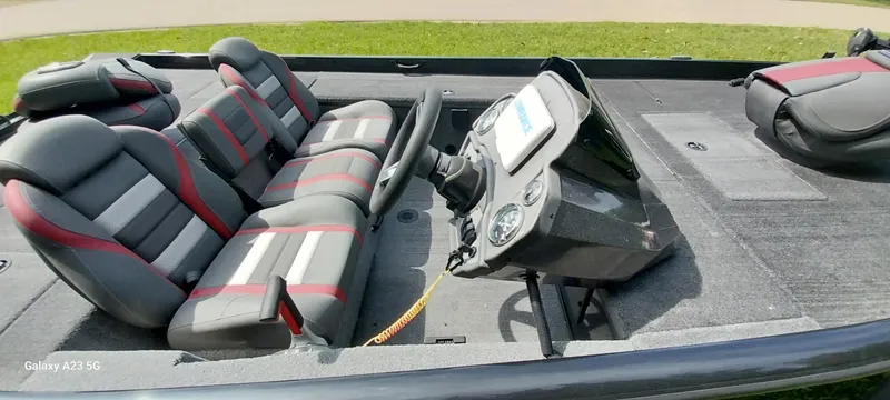 Slide: The Image of 2024 Ranger RT178C boat interior with gray and red seating, steering console, and carpeted flooring. - 8