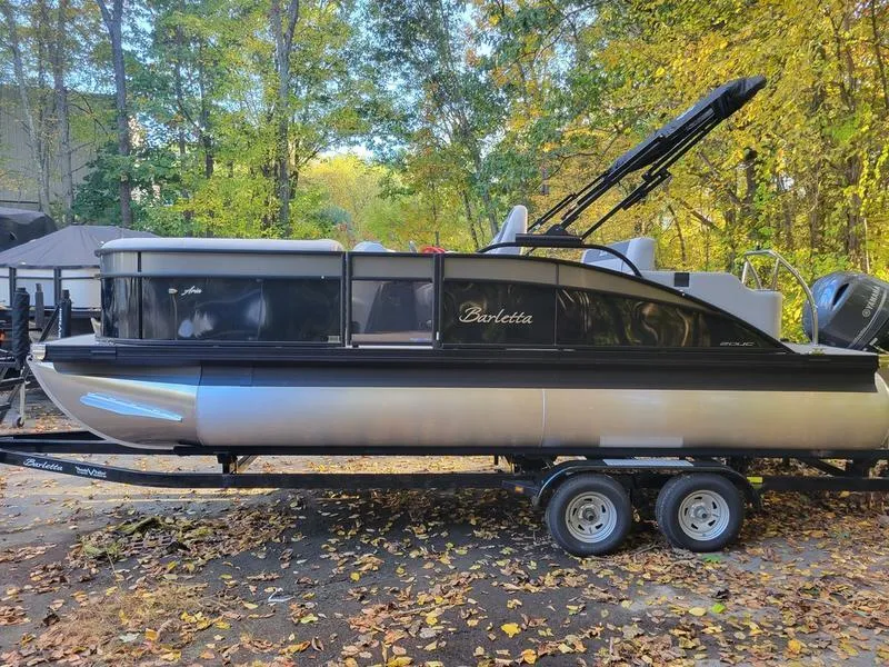 Slide: The Image of 2025 Barletta A20UC pontoon boat on trailer, surrounded by autumn leaves. - 4
