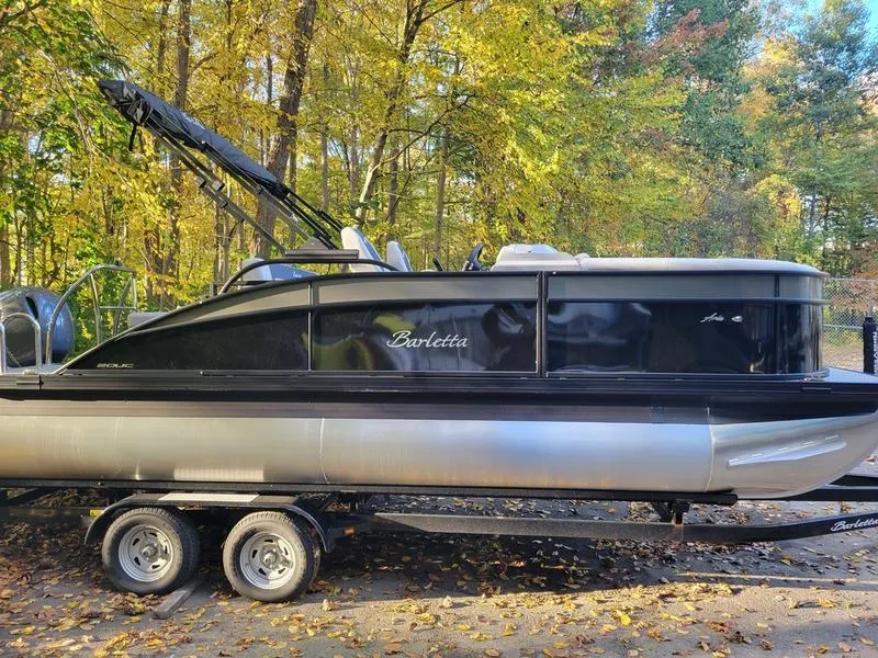 Slide: The Image of 2025 Barletta A20UC pontoon boat on trailer, surrounded by autumn trees. - 5