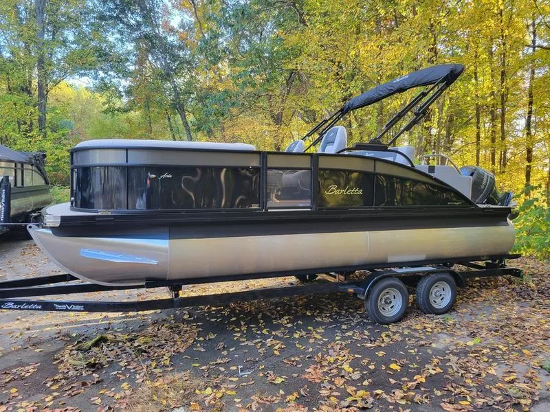 Slide: The Image of 2025 Barletta A20UC pontoon boat on trailer in a wooded area. - 8