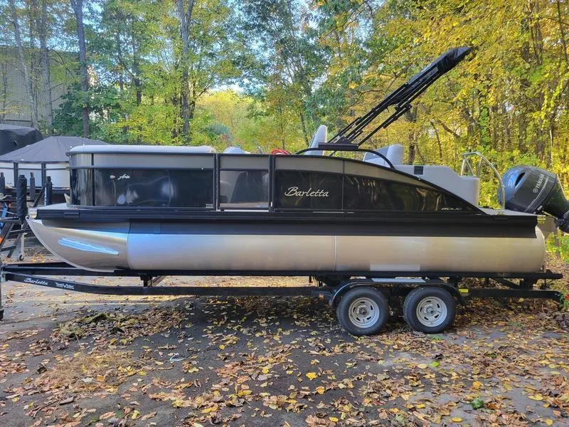 Slide: The Image of 2025 Barletta A20UC pontoon boat on trailer, surrounded by autumn foliage. - 9