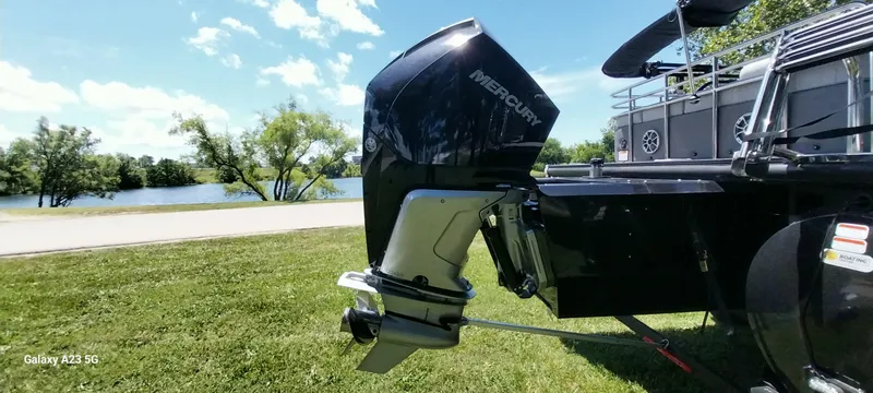 Slide: The Image of 2023 Regency 250 LE3 Sport boat with Mercury outboard motor by a scenic lake. - 13