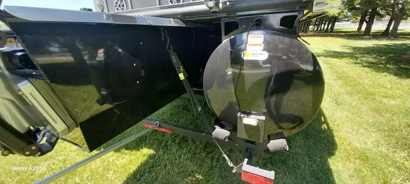 Slide: The Image of 2023 Regency 250 LE3 Sport boat trailer hitch on grassy area. - 15