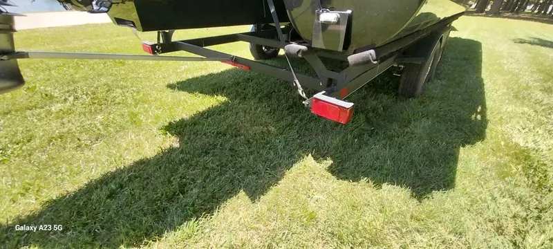 Slide: The Image of 2023 Regency 250 LE3 Sport trailer on grass, rear view with red reflector. - 17