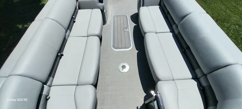 Slide: The Image of 2023 Regency 250 LE3 Sport boat interior with spacious gray seating and central storage compartment. - 32