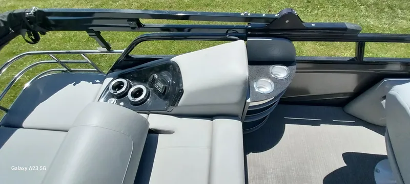 Slide: The Image of 2023 Regency 250 LE3 Sport boat interior with cup holders and seating, on a sunny day. - 39