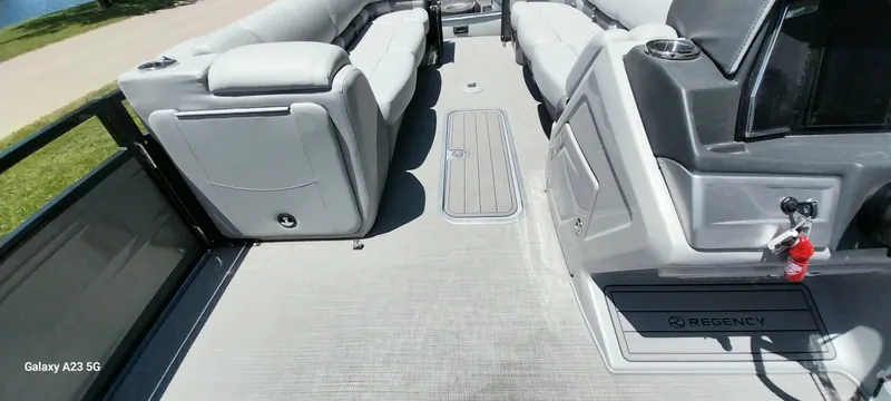 Slide: The Image of 2023 Regency 250 LE3 Sport pontoon boat interior with plush seating and modern design. - 40