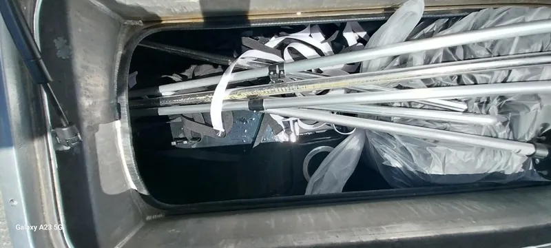 Slide: The Image of Storage compartment of 2023 Regency 250 LE3 Sport with poles and equipment inside. - 43